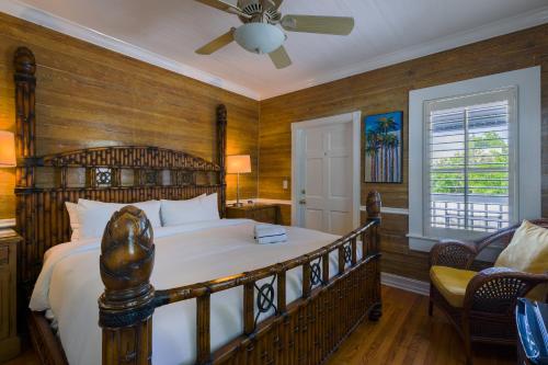 a bedroom with a large bed and a ceiling fan at Duval Inn - Key West in Key West