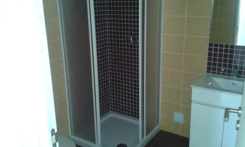 a shower with a glass door next to a sink at Casa Almeida in Vimieiro