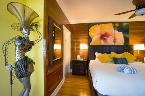 a bedroom with a bed with a mermaid statue on the wall at Duval Inn - Key West in Key West