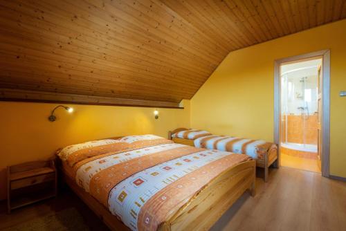 a row of beds in a room with a wooden ceiling at Villa Dam in Liptovský Mikuláš