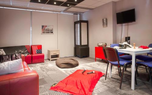 a living room with a red couch and a table at Hôtel Club MMV Le Flaine in Flaine