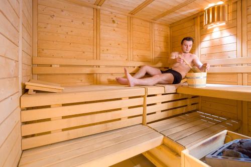 a man is sitting in a sauna at Hôtel Club MMV Le Flaine in Flaine