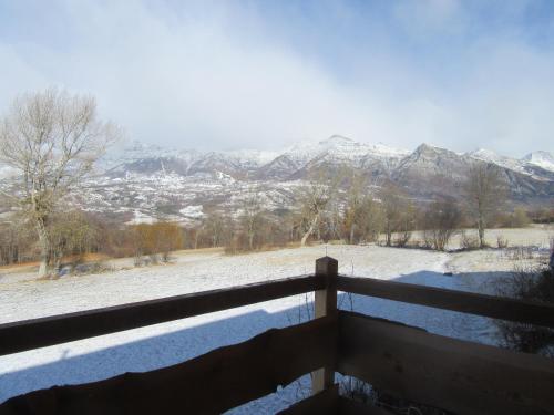a view of a snowy mountain range from a balcony at Gîte Potimarron in Ancelle