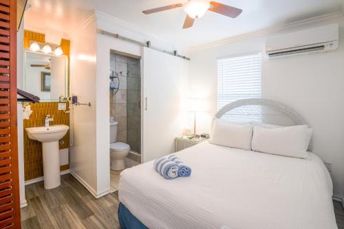 a bedroom with a white bed and a bathroom at Duval Inn - Key West in Key West