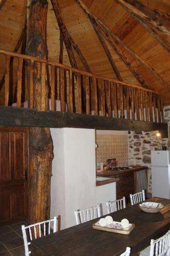 a dining room with a wooden table and chairs at Alojamiento Los Chozos in Cazalla de la Sierra