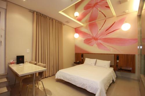 um quarto de hotel com uma cama e uma mesa em Vitara Motel (Adult Only) em Taboão da Serra