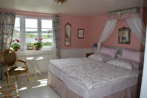 Schlafzimmer mit einem Bett mit rosa Wänden und einem Fenster in der Unterkunft Bed & Breakfast mit Charme- Aux2platanes- Außergewöhnlich schön am Bodensee in Salem
