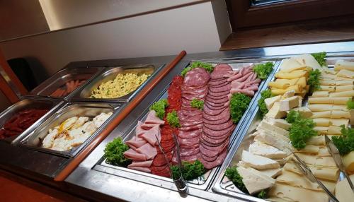 a buffet of different types of meats and cheese at Lostrita - Pastravarie, Hotel & SPA in Baia Mare