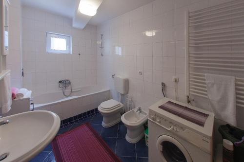 a bathroom with a sink and a toilet and a tub at Guesthouse Rota in Mostar