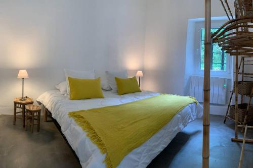 a bedroom with a large bed with yellow pillows at Magnifique Mas Cevenol in Anduze