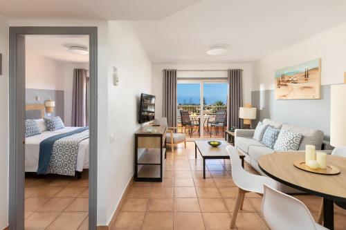 Habitación de hotel con cama y sala de estar. en Sol Barbacan, en Playa del Inglés