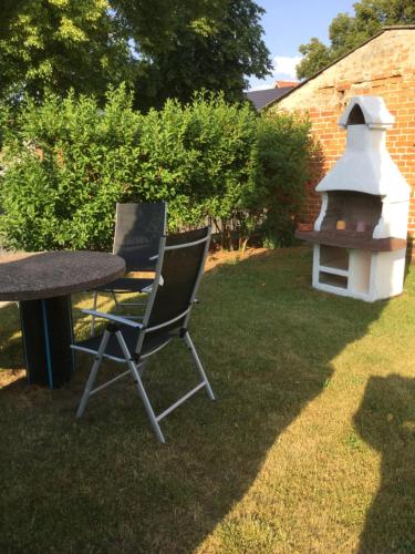 a table and two chairs next to a bird house at Ferienwohnung Sonnenberg Dahmeblick in Märkisch Buchholz