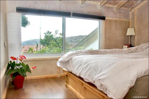 una camera con un letto e una grande finestra di Vitals On the Mountain in Katzir a Katzir 