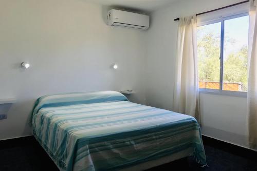 ein weißes Schlafzimmer mit einem Bett und einem Fenster in der Unterkunft Aparts de Montaña Tavullia in Carpintería