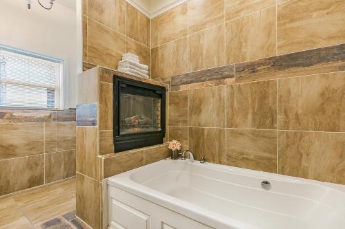 a bathroom with a white tub and a tv at Spacious 4BR City Condo steps from St Charles Ave in New Orleans