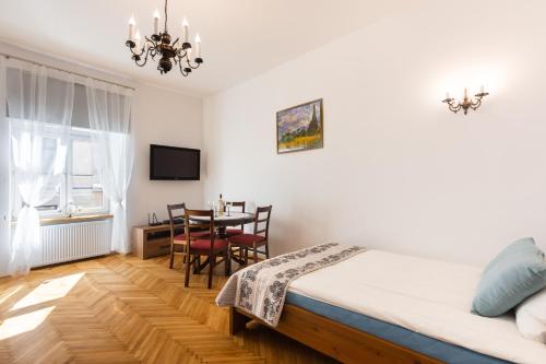 een slaapkamer met een bed en een tafel met stoelen bij Bridge Apartments 6 in Krakau