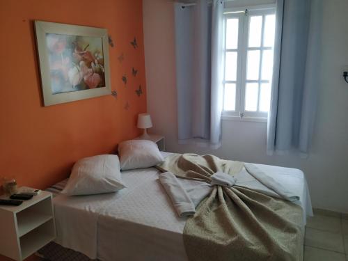 a bedroom with a bed with a bow on it at Apartamentos beira mar in Porto De Galinhas