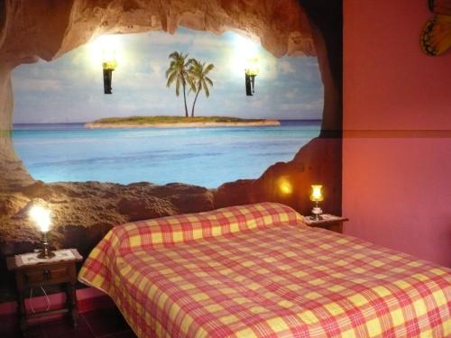 a bedroom with a bed with a painting of a beach at las flores in Almuñécar