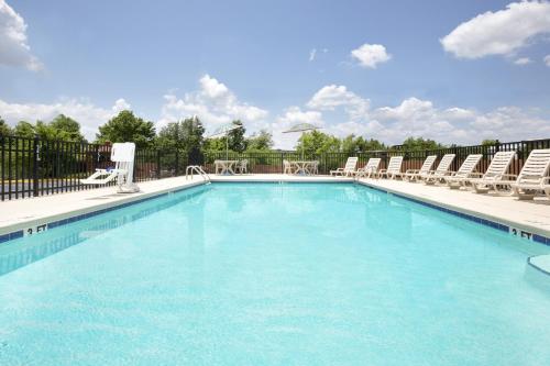 a large swimming pool with chairs at Days Inn by Wyndham Columbus-North Fort Moore in Columbus