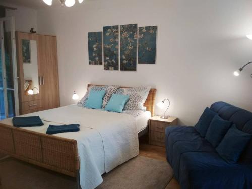 Un dormitorio con una cama y un sofá azul. en Zsuzsa Apartman, en Budapest