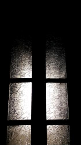 a window in a dark room with the light shining through it at Private Room In Apartment with Sea & Hilton View in Alexandria