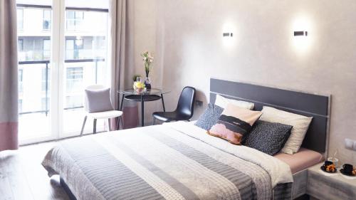 a bedroom with a large bed and a window at Art Apartments II in Wrocław