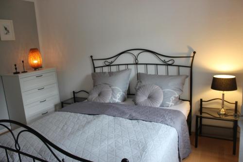 a bedroom with a bed and a dresser and lamp at Wohnen am Solbad in Bad Salzungen