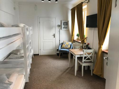 Pokój z 2 łóżkami piętrowymi, biurkiem i stołem w obiekcie Hostel Coco w Warszawie