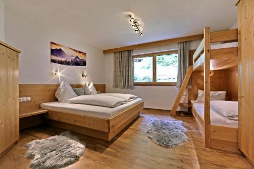 a bedroom with two bunk beds and a ladder at Apart Bergkristall Zellberg in Zellberg