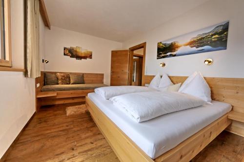 a bedroom with a large bed and a couch at Apart Bergkristall Zellberg in Zellberg