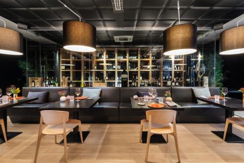 a restaurant with a couch and tables and chairs at Eurostars Palacio de Cristal in Oviedo