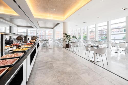 a restaurant with a buffet line with tables and chairs at Eurostars Palacio de Cristal in Oviedo