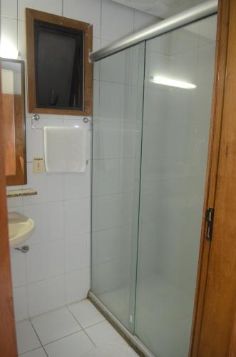 a bathroom with a glass shower with a television in it at River Hotel in Uruguaiana