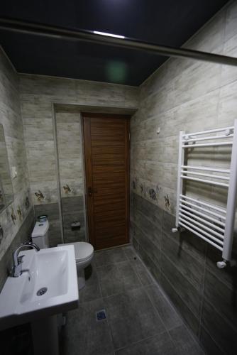 a bathroom with a sink and a toilet at Hotel Daisy S Home in Kutaisi