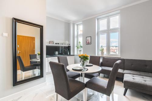 a living room with a table and chairs and a mirror at Panorama Przemyśl in Przemyśl