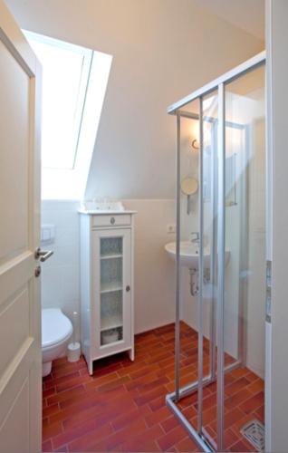 a bathroom with a shower and a toilet and a sink at Ferienwohnung Spatzennest in Prerow