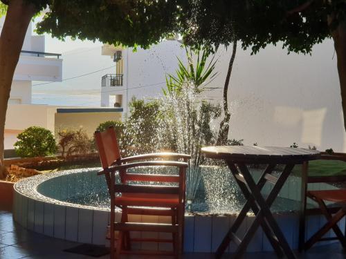 a table and two chairs next to a fountain at Amazones Villas Apartments in Stalís