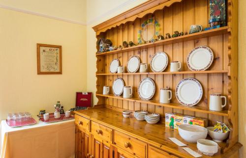 einem Holzschrank mit Platten und Schalen darauf in der Unterkunft Dorchester House in Keswick