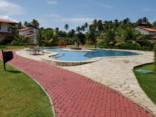 a brick walkway around a swimming pool in a resort at Flat Club Meridional in Tamandaré