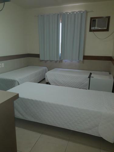 a room with two beds and a window at River Hotel in Uruguaiana