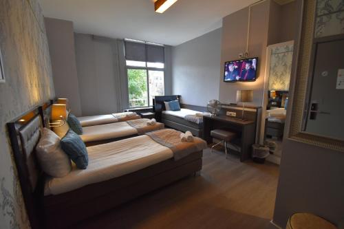 a living room with a bed and a couch at Hotel Hermitage Amsterdam in Amsterdam