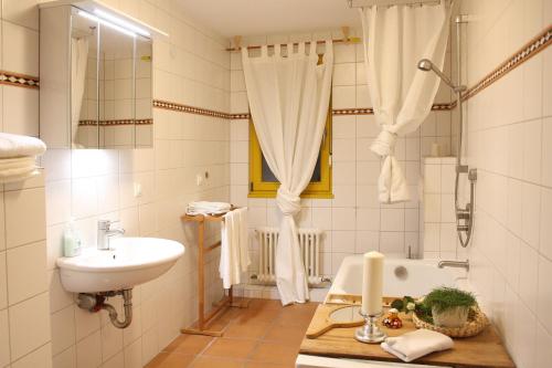 Baño blanco con lavabo y bañera en Gut Müllerleile, en Gengenbach