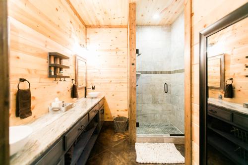 La salle de bains en bois est pourvue d'une douche et d'un lavabo. dans l'établissement Fireside Creek Luxury Cabin, à Stephens Gap