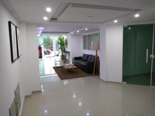 - un salon avec un canapé et un mur vert dans l'établissement Apartamento Com Vista Para o Mar Com 2 Vagas de Garagem, à Arraial do Cabo