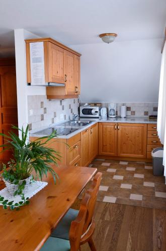 a kitchen with wooden cabinets and a wooden table at Apartma in Bungalov Jezerci in Gozd Martuljek