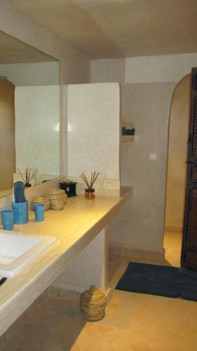 a kitchen with a counter with a sink and a mirror at Dar Kamango in Marrakesh