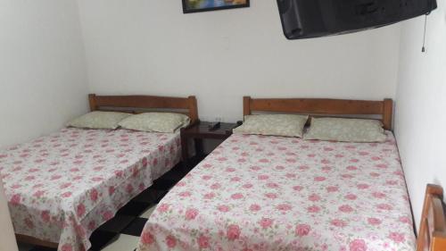 two beds sitting next to each other in a bedroom at Hospedaje Santa Bárbara in Buga