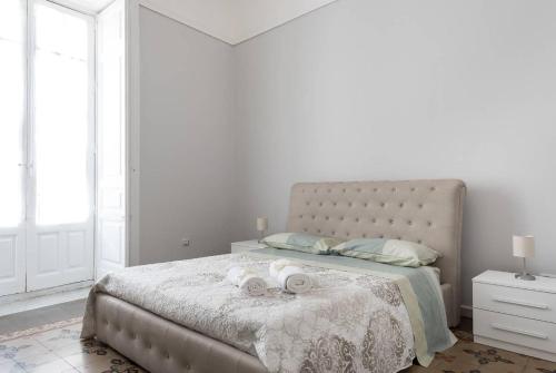 カターニアにあるGramignani House Cataniaのベッドルーム1室(大型ベッド1台、タオル2枚付)