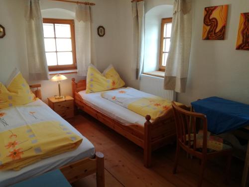 1 dormitorio con 2 camas, mesa y 2 ventanas en Jenny en Lembach im Mühlkreis