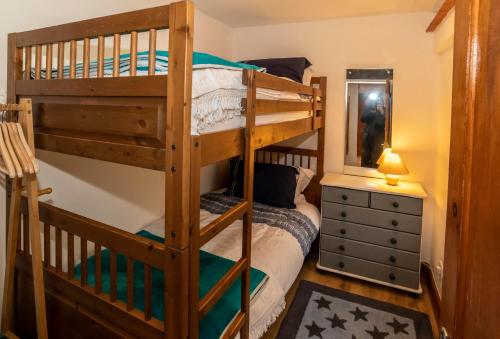 a bedroom with two bunk beds and a dresser at Eithin Bach in Caernarfon